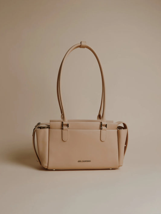 Ivory handbag with two long handles and a minimalist design.