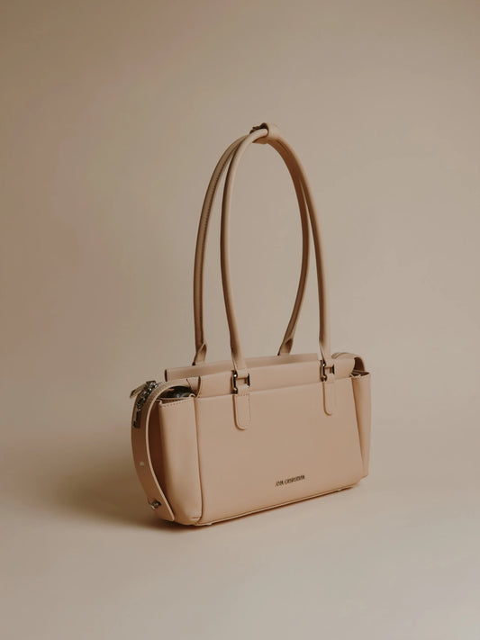 Ivory handbag shown from the side with a smooth finish.