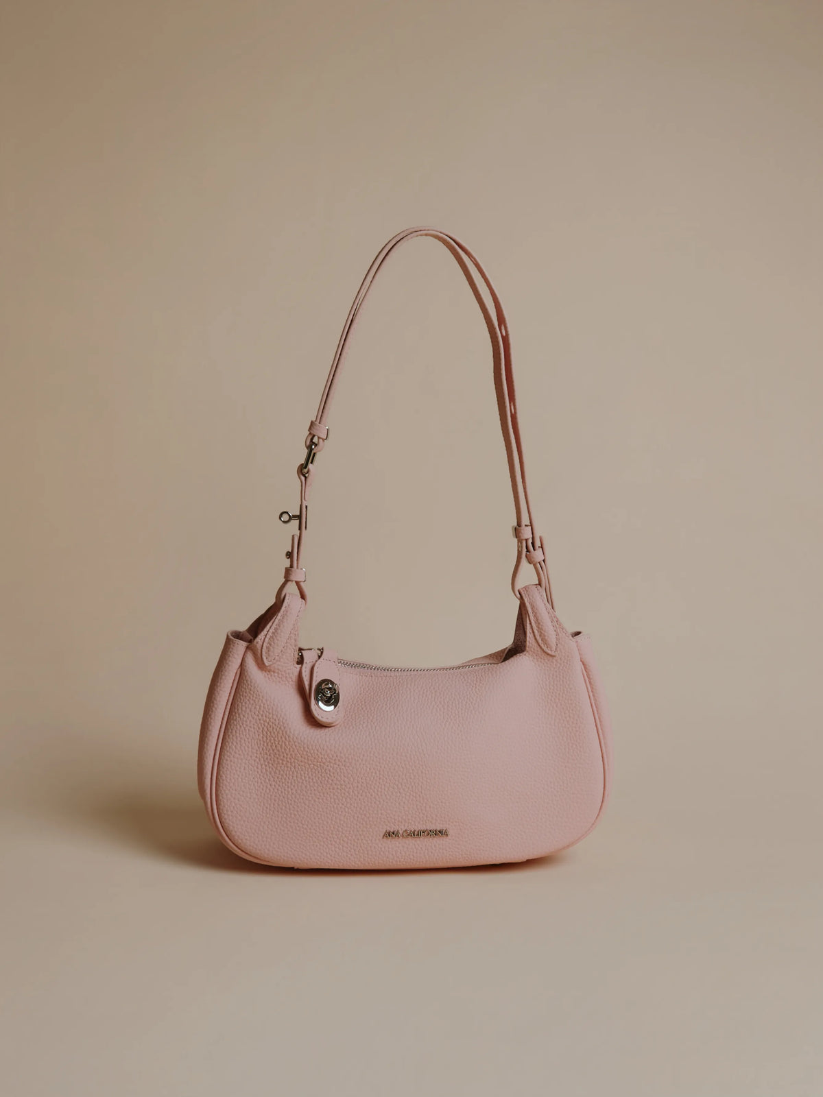 Light pink leather handbag with a shoulder strap.