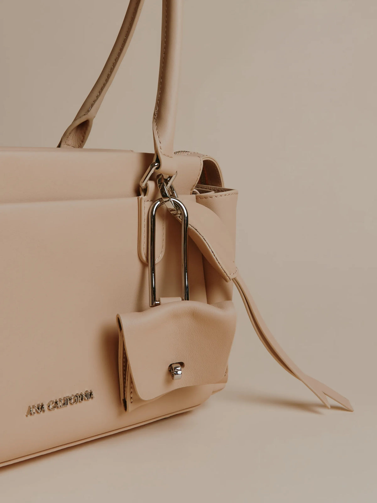 Ivory handbag with zippered structure and side view.