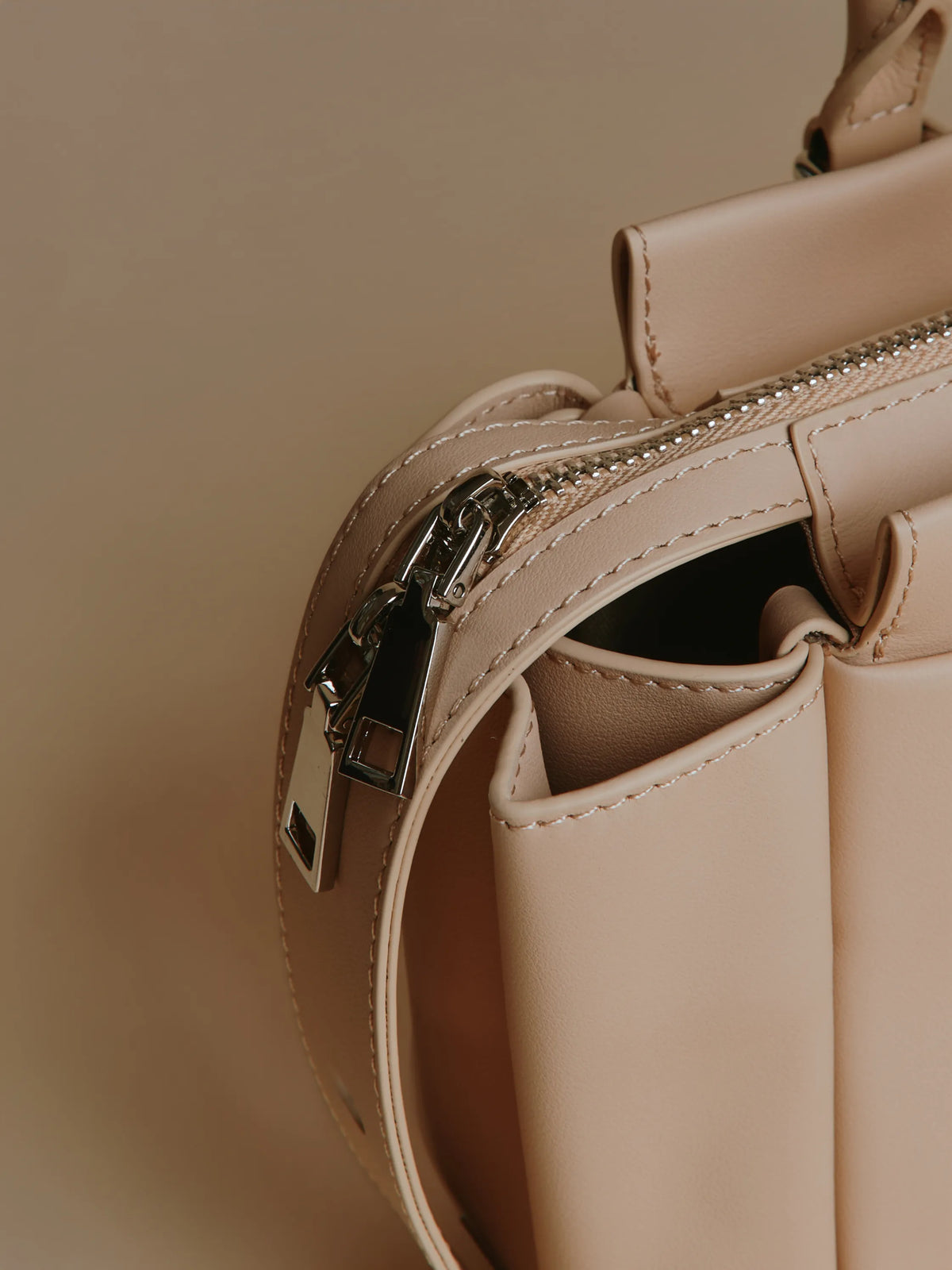 Ivory handbag featuring a small charm on the side.